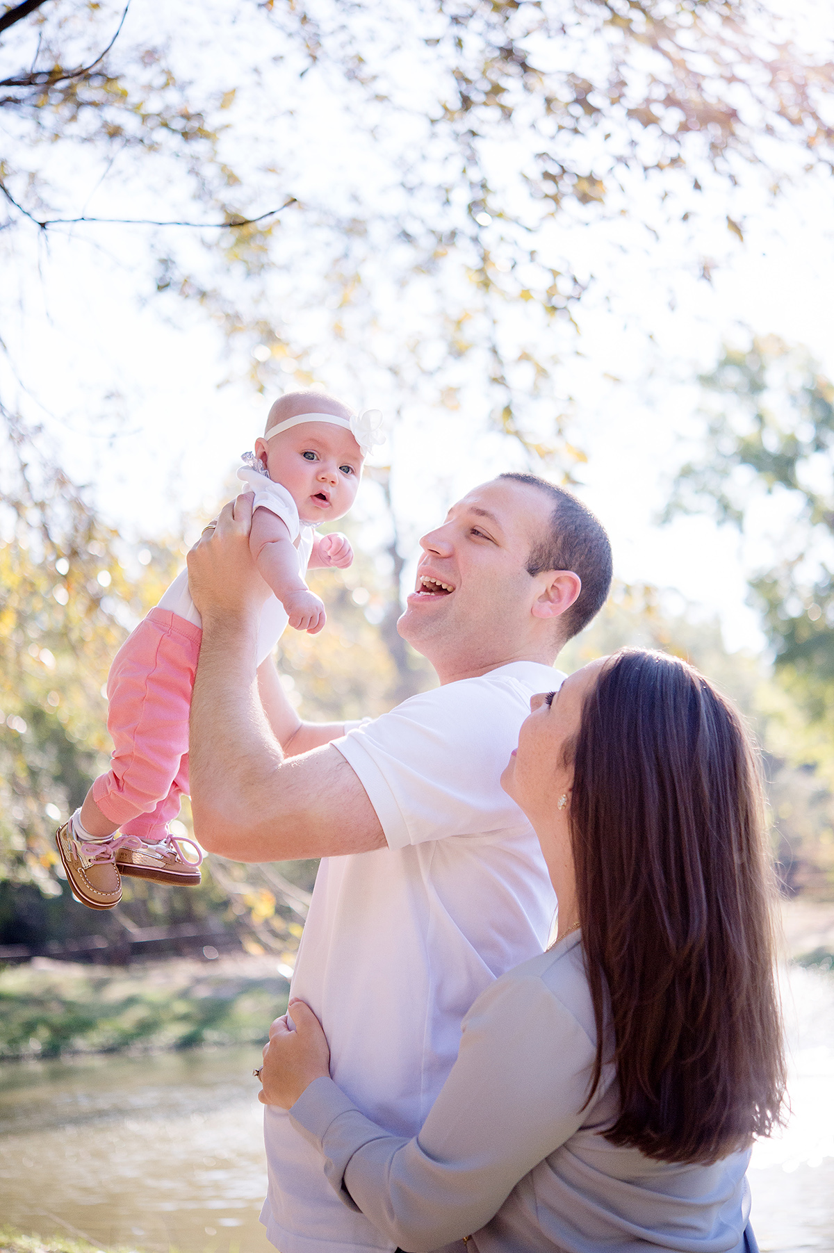 daddy holding baby in air for family photos